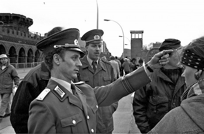 Interested artists, David Monty and GDR border soldiers viewing the Wall section from Oberbaumbrücke after the press conference, 29.1.1990