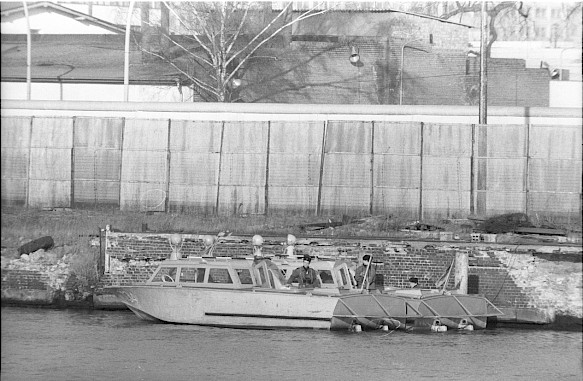 A boat of the GDR border troops in front of a fence on the East Berlin side of the Spree River, 1980