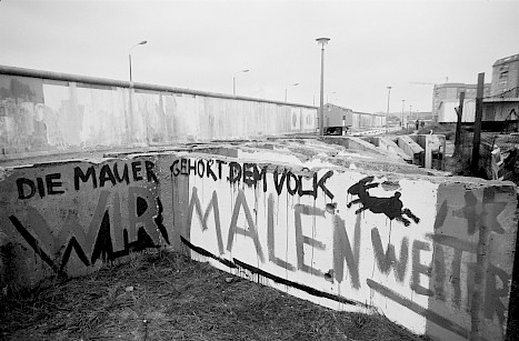 A protest against whitewashing the artist’s paintings at Potsdamer Platz with the whitewashed border wall in the background, November 1989