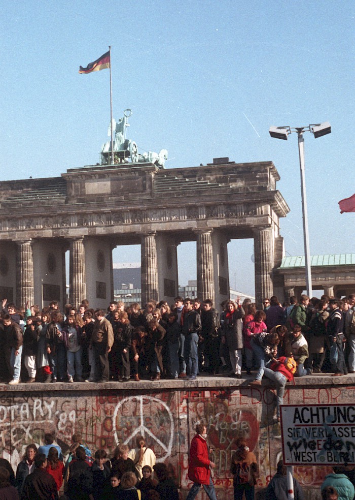 People at the Brandenburg Gate celebrate the opening of the GDR border on 10 November 1989